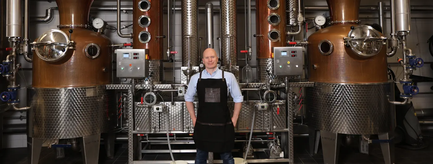 Marcel Amann between the copper stills of the distillery